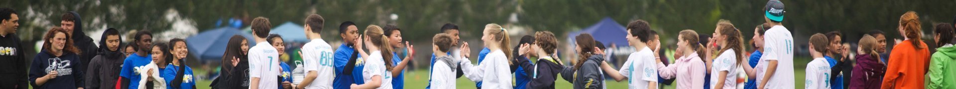 Two youth teams line up to high-five each other after a game