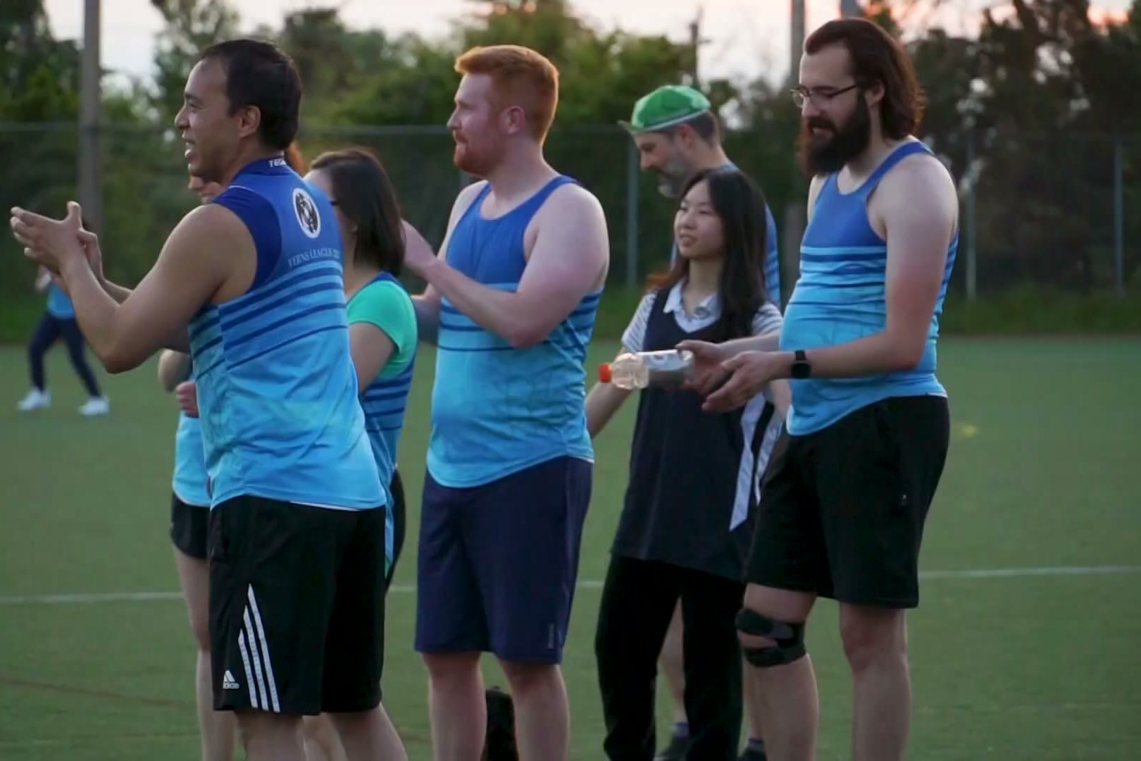 A line of league players applauding at golden hour