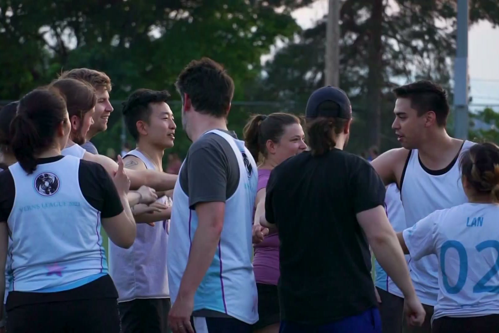Two teams greeting each other after an evening game